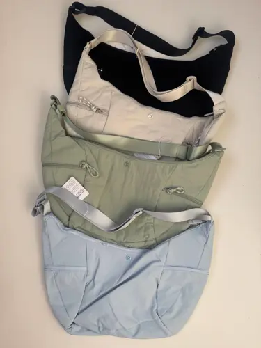 کیف اسلوچی اسلینگ 13 لیتری Lululemon، کیف‌های اسلینگ مشکی، کرم، زیتونی و آبی روشن با جیب بیرونی روی سطح روشن - تصویر اصلی