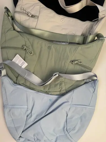 کیف اسلوچی اسلینگ 13 لیتری Lululemon، کیف‌های اسلینگ مشکی، کرم، زیتونی و آبی روشن با جیب بیرونی روی سطح روشن