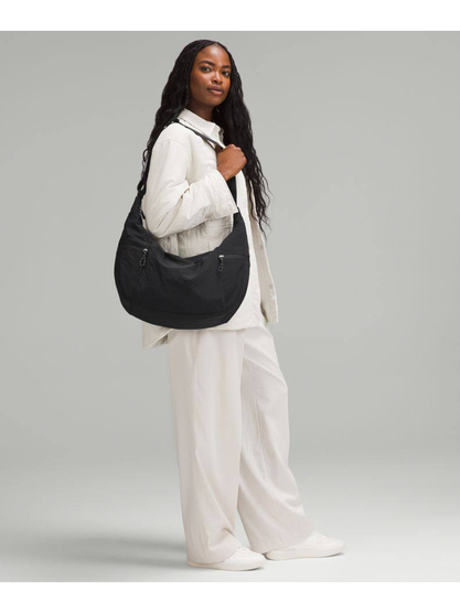 کیف اسلوچی اسلینگ 13 لیتری Lululemon، کیف اسلینگ مشکی روی شانه مدل با لباس سفید