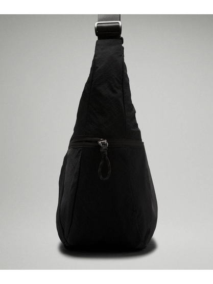 کیف اسلوچی اسلینگ 13 لیتری Lululemon، نمای جانبی کیف اسلینگ مشکی با جیب جمع‌شونده و بند قابل‌تنظیم