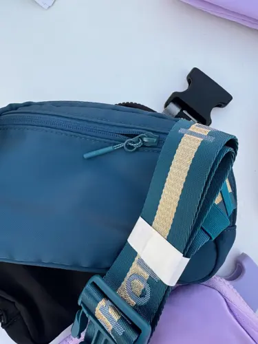 بلت بگ وردمارک Lululemon، آبی تیره؛ نمای نزدیک زیپ و بند راه‌راه با نوشته lululemon