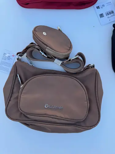 کراس بادی نانو پوچ 2 لیتری Lululemon، قهوه‌ای با کیفک گرد و نشان لولولمون؛ از جلو روی زمینه روشن