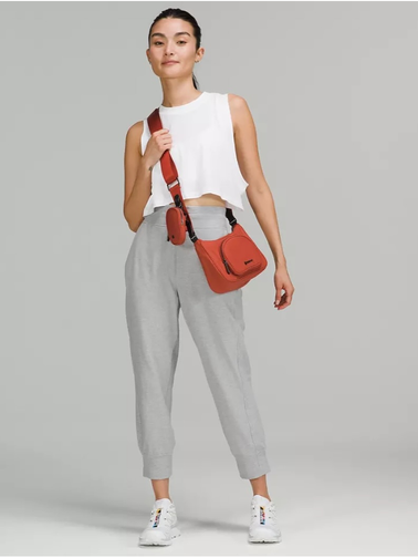 کراس بادی نانو پوچ 2 لیتری Lululemon، نارنجی؛ کیف روی شانه مدل با کراپ سفید و شلوار خاکستری