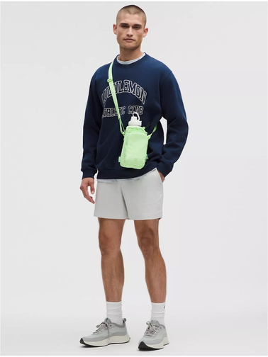 باتل بگ اورجینال Lululemon، سبز روشن؛ کیف بنددار روی شانه مدل مرد با بلوز سرمه‌ای و شلوارک سفید