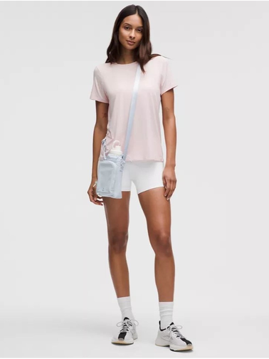 باتل بگ اورجینال Lululemon، سفید؛ روی شانه مدل زن با تیشرت صورتی و شلوارک روشن
