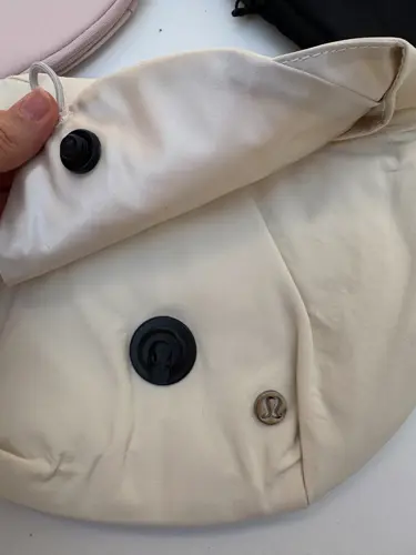 بلت بگ 3 لیتری Lululemon، کرم؛ نمای نزدیک درپوش باز و دکمه‌های مشکی کیف در دست