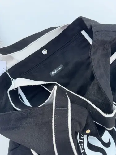 توت بگ کتان Lululemon، مشکی؛ نمای داخل کیف باز با جیب و دکمه فلزی