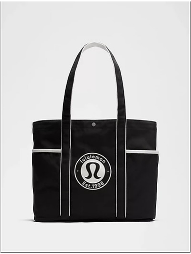 توت بگ کتان Lululemon، مشکی با خطوط سفید و لوگوی گرد لولولمون؛ از جلو روی زمینه سفید