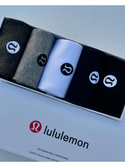 جوراب ساقدار Lululemon، جوراب‌های مشکی، خاکستری و سفید رول‌شده در جعبه باز، کنار در سفید با لوگوی lululemon - تصویر دوم