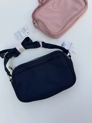 کراس بادی کمرا بگ 2 لیتری Lululemon، دو کیف مستطیلی سرمه‌ای و صورتی با دو زیپ و بند پهن، روی زمینه روشن