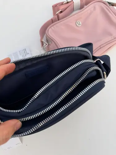 کراس بادی کمرا بگ 2 لیتری Lululemon، سرمه‌ای؛ نمای نزدیک محفظه‌های زیپ‌دار باز کیف در دست