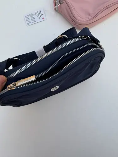 کراس بادی کمرا بگ 2 لیتری Lululemon، سرمه‌ای؛ نمای نزدیک محفظه‌های زیپ‌دار باز کیف در دست