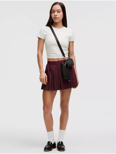 کیف دوتکه Lululemon، مشکی؛ کیف دوتکه روی شانه مدل با تیشرت سفید و دامن زرشکی