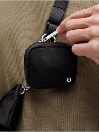 کیف دوتکه Lululemon، مشکی؛ نمای نزدیک قلاب و کیفک مربع روی بند در دست مدل