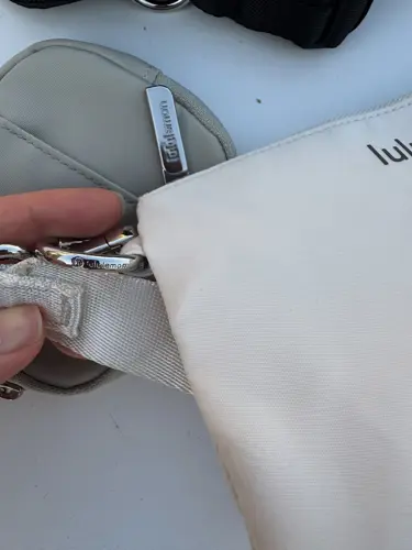 کیف دوتکه Lululemon، کرم؛ نمای نزدیک قلاب فلزی و اتصال بند در دست