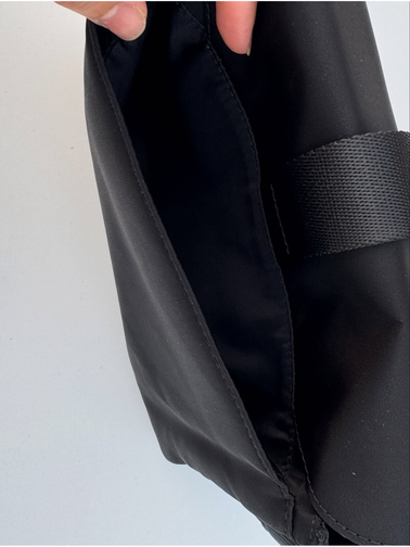 کیف دوشی مولتی پاکت Lululemon، مشکی؛ نمای داخل کیف باز با جیب و نوشته lululemon