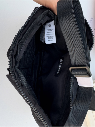 کراس بادی مولتی پاکت Lululemon، مشکی؛ نمای داخل کیف باز با جیب و برچسب، بند روی دهانه