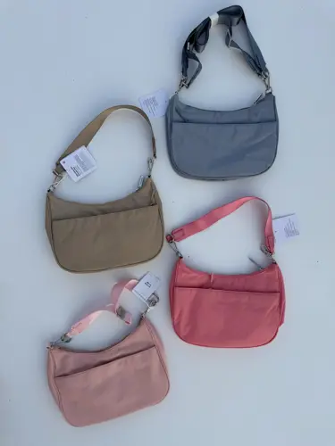 کیف شولدر Lululemon، کیف‌های شانه‌ای بژ، صورتی، آبی خاکستری و صورتی چرک با بند کوتاه، روی زمینه روشن