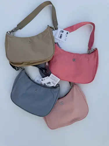 کیف شولدر Lululemon، کیف‌های شانه‌ای بژ، صورتی، آبی خاکستری و صورتی چرک با بند کوتاه، روی زمینه روشن - تصویر اصلی