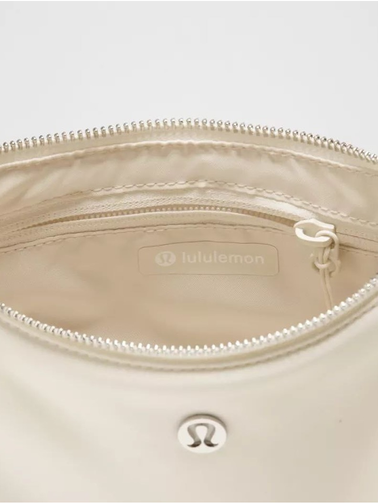 کیف شولدر Lululemon، کرم؛ نمای داخل کیف باز با جیب زیپ‌دار و آستر روشن