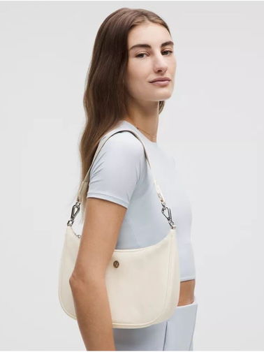 کیف شولدر Lululemon، کرم؛ روی شانه مدل با لباس آبی بسیار روشن