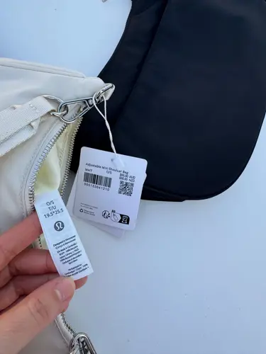 کیف شولدر Lululemon، کرم؛ نمای نزدیک برچسب مشخصات و بند در دست