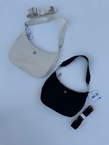 کیف شولدر Lululemon، دو کیف کرم و مشکی با بند کوتاه و بند جداشونده، روی زمینه روشن