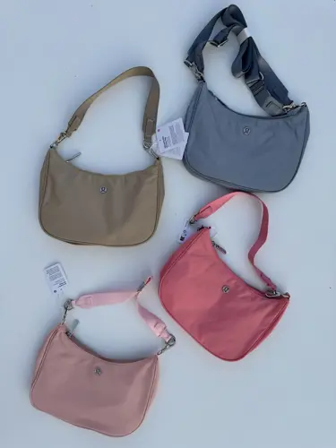 کیف شولدر Lululemon، کیف‌های شانه‌ای بژ، صورتی، آبی خاکستری و صورتی چرک با بند کوتاه، روی زمینه روشن
