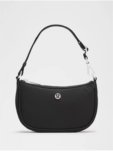 کیف مینی شولدر Lululemon، کیف مینی مشکی با دسته کوتاه و لوگوی فلزی نقره‌ای از روبه‌رو روی پس‌زمینه سفید