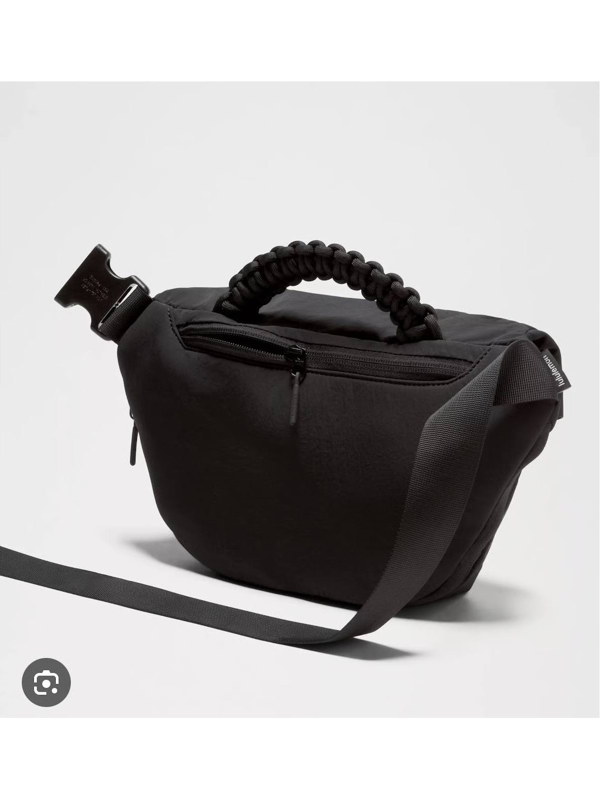 بلت بگ 3 لیتری Lululemon، پشت کیف کمری مشکی با جیب زیپ‌دار، دسته بافته‌شده و بند بلند روی پس‌زمینه روشن