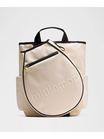 کیف تنیسی راکت بگ Lululemon، کیف تنیس کرم با دسته و لبه مشکی و کاور راکت متصل به جلو روی پس‌زمینه روشن - تصویر اصلی