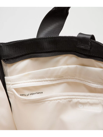 کیف تنیسی راکت بگ Lululemon، نمای نزدیک آستر و جیب داخلی کیف تنیس کرم با لبه و دسته مشکی