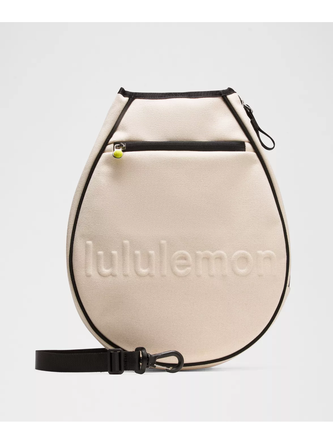 کیف تنیسی راکت بگ Lululemon، کاور راکت کرم با لبه و بند مشکی و نوشته برجسته lululemon روی پس‌زمینه روشن