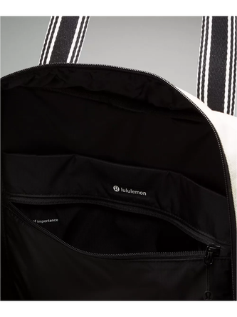 کیف تنیسی کانواس Lululemon، نمای نزدیک داخل کیف تنیس با آستر مشکی، جیب زیپ‌دار و برچسب lululemon