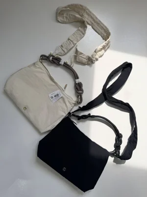 کراس بادی کانورتیبل چین‌دار Lululemon 6.5L؛ دو کیف مشکی و شیری با بند چین‌دار و بند طنابی روی سطح روشن