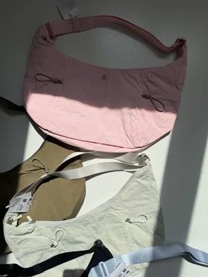کیف اسلوچی اسلینگ Lululemon 13L صورتی؛ نمای جلو، دو جیب زیپ‌دار و بند تنظیم