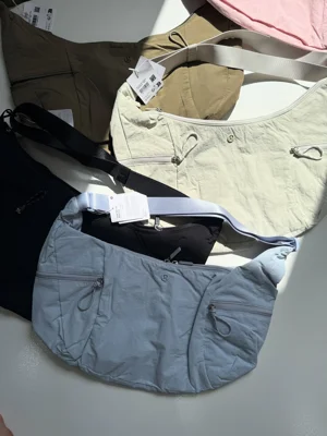 کیف اسلوچی اسلینگ Lululemon 13L؛ نمای کیف‌های آبی، شیری و سبز زیتونی کنار بندها