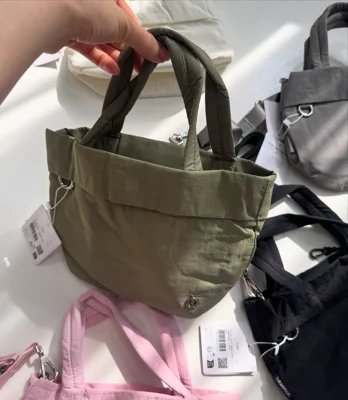 توت بگ آن مای لول اسمال Lululemon؛ کیف سبز زیتونی در دست؛ نمای دسته‌ها، حلقه جلو و نشان فلزی - تصویر دوم