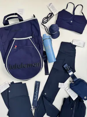 کیف تنیسی راکت بگ Lululemon، کیف تنیس سرمه‌ای و کاور راکت، کنار بطری آبی، نیمتنه، لگ، کیف‌های کوچک و لوازم سرمه‌ای