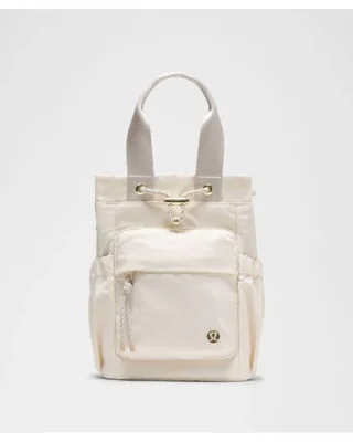 باکت بگ کانورتیبل مینی Lululemon 5L شیری؛ نمای ژورنالی جلو، دهانه جمع‌شونده و جیب زیپ‌دار بیرونی