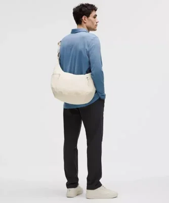 کیف اسلوچی اسلینگ Lululemon 13L شیری روی شانه مدل از پشت با پیراهن آبی