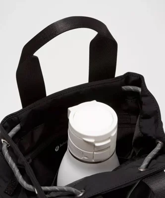 باکت بگ کانورتیبل مینی Lululemon 5L مشکی؛ جیب بطری داخل کیف با بطری برای نمایش کاربرد فضای داخلی
