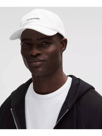 کلاه بال کپ Wordmark Lululemon، کلاه سفید با نوشته مشکی lululemon روی سر مدل با ژاکت مشکی - تصویر اصلی