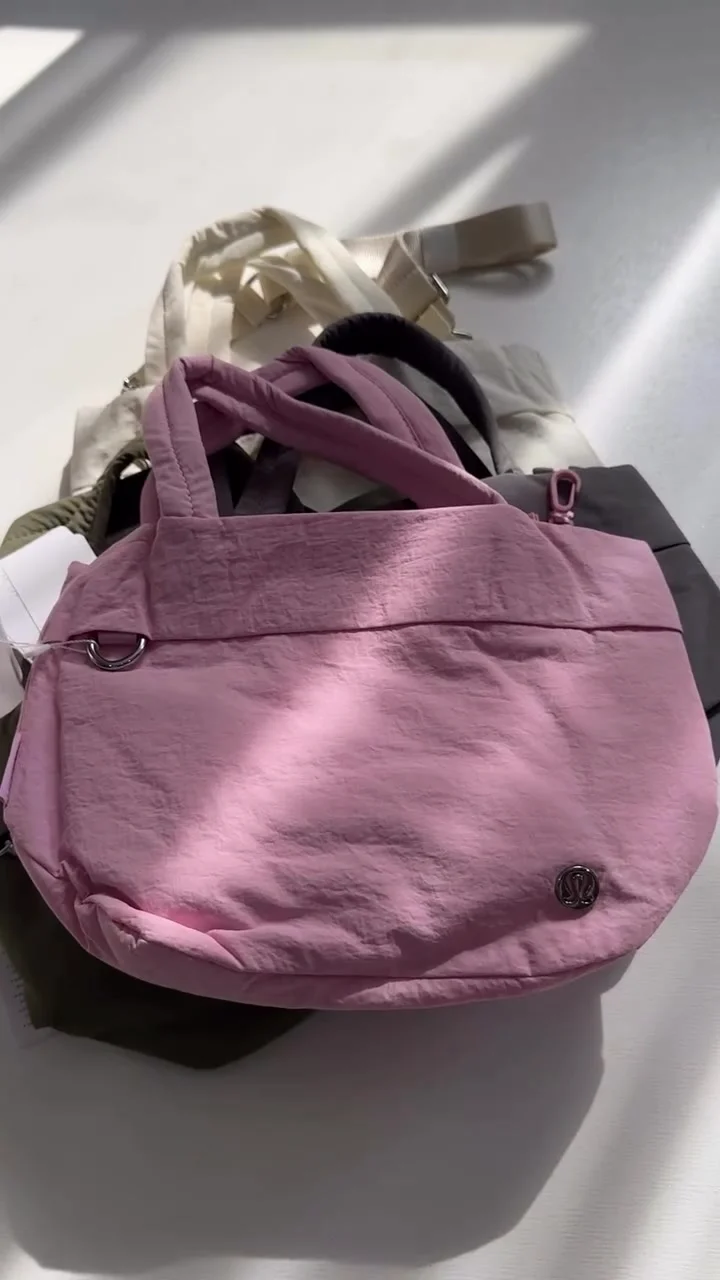 توت بگ آن مای لول اسمال Lululemon صورتی در نمای جلو با لوگو؛ رنگ‌های دیگر در پس‌زمینه