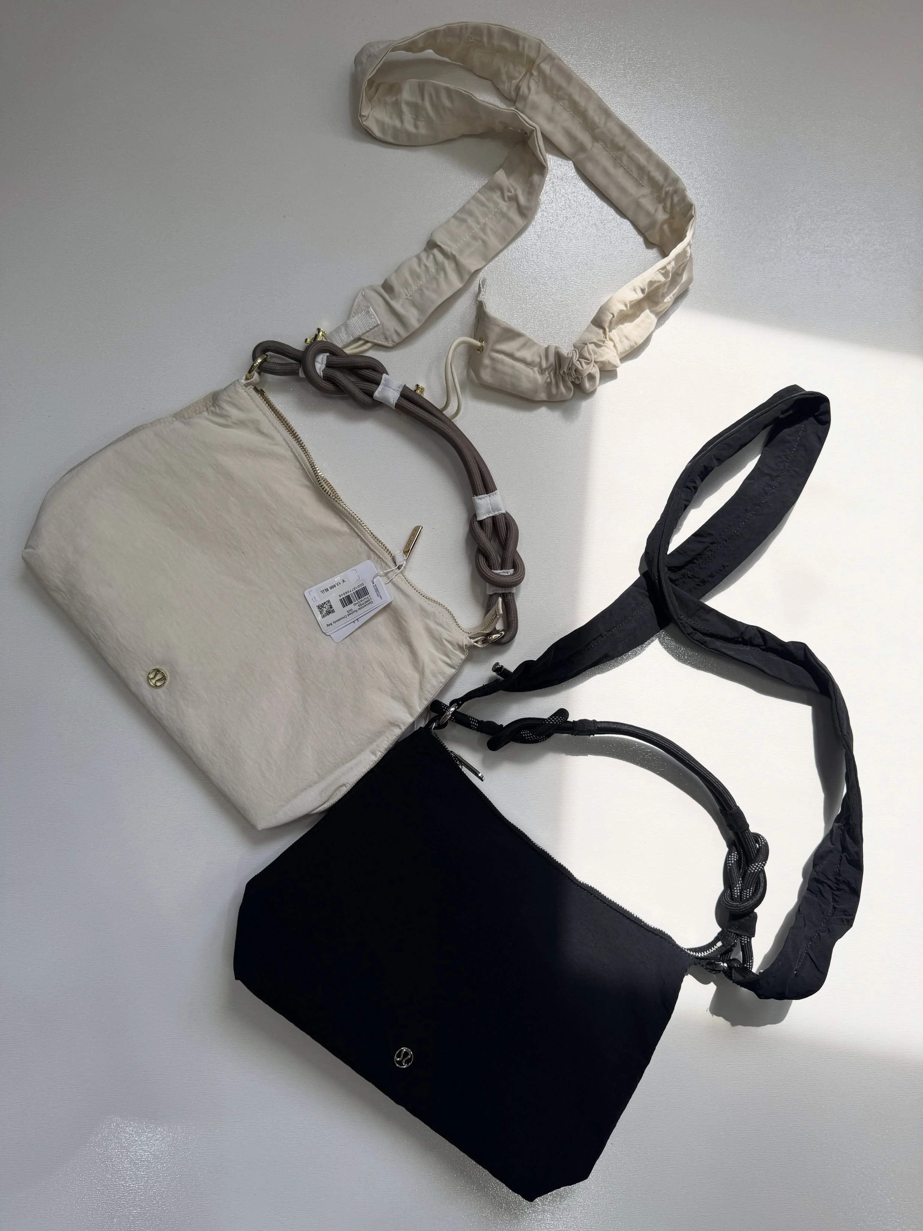 کراس بادی کانورتیبل چین‌دار Lululemon 6.5L؛ دو کیف مشکی و شیری با بند چین‌دار و بند طنابی روی سطح روشن
