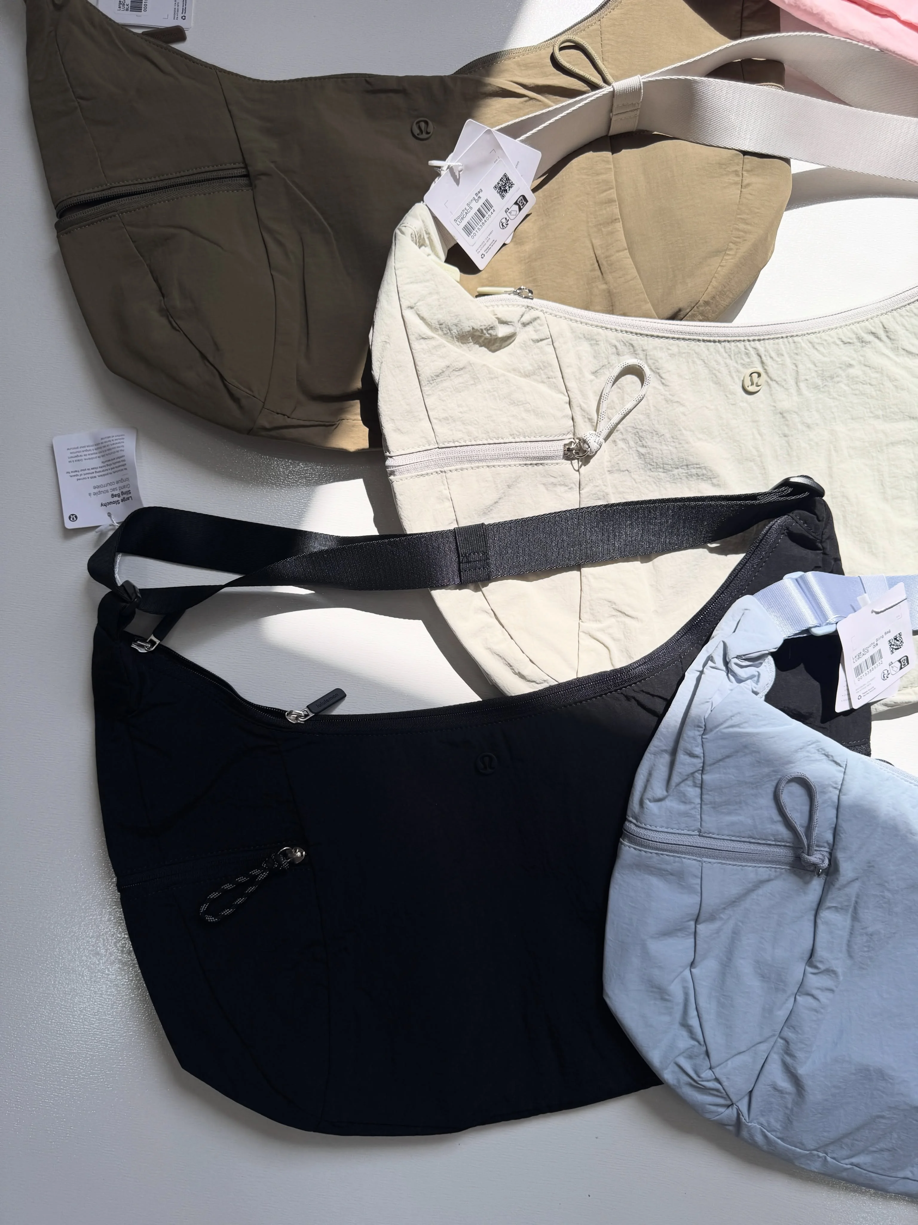 کیف اسلوچی اسلینگ Lululemon 13L؛ مقایسه رنگ‌های زیتونی، شیری، مشکی و آبی از جلو