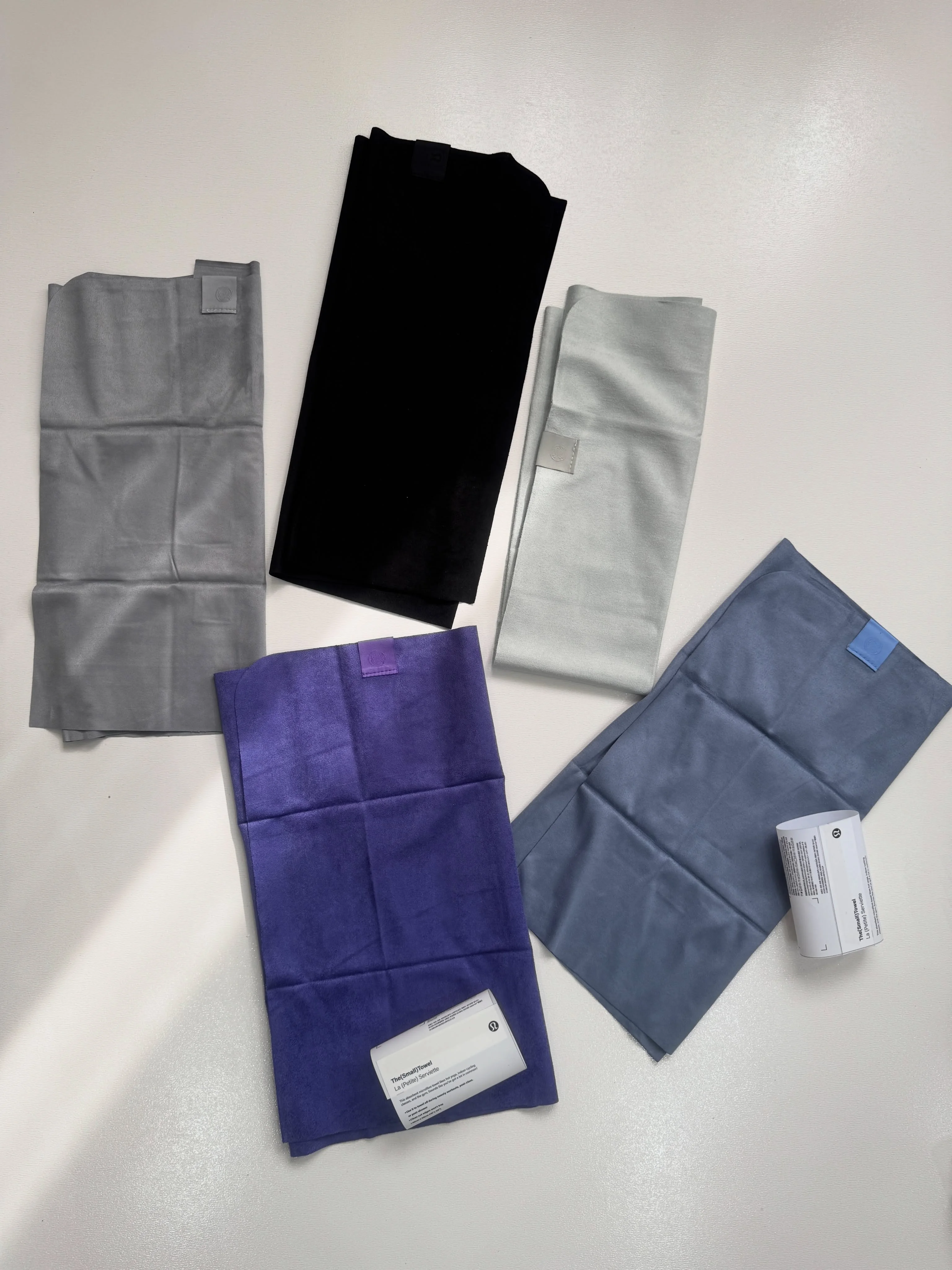 حوله کوچک Lululemon؛ نمایش هر پنج رنگ آبی‌خاکستری، بنفش، طوسی، سبز سیج و مشکی