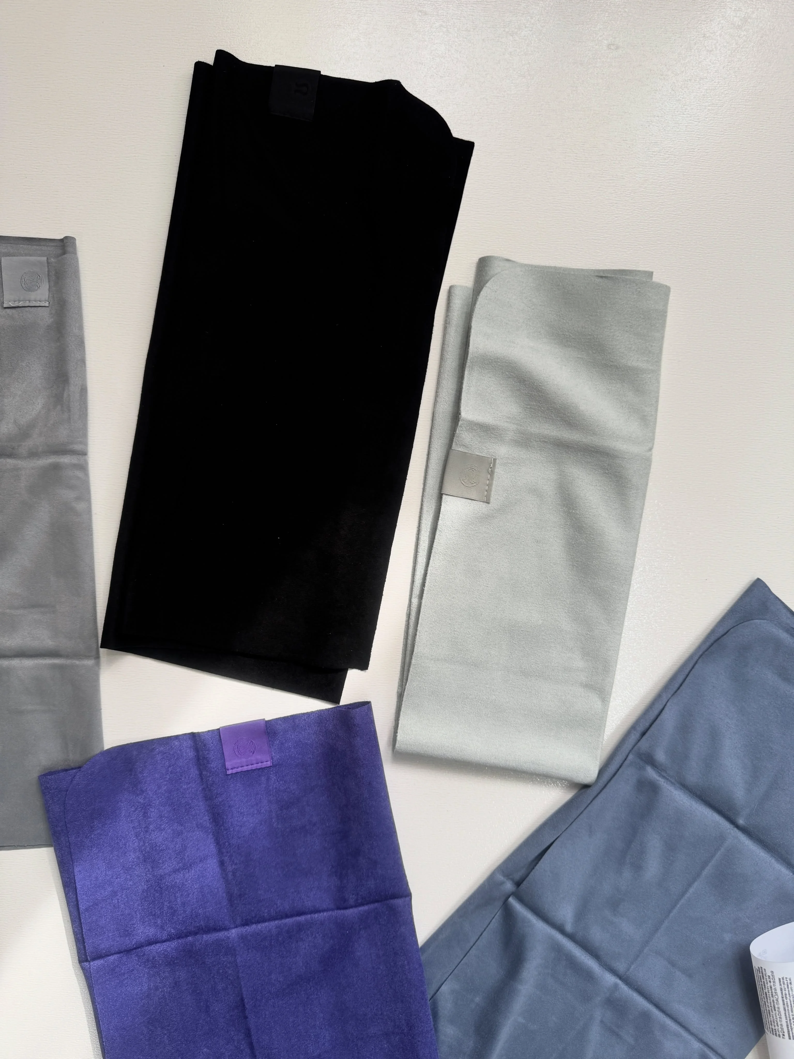 حوله کوچک Lululemon سبز سیج و مشکی؛ نمای لوگوی گوشه در کنار بنفش و آبی‌خاکستری