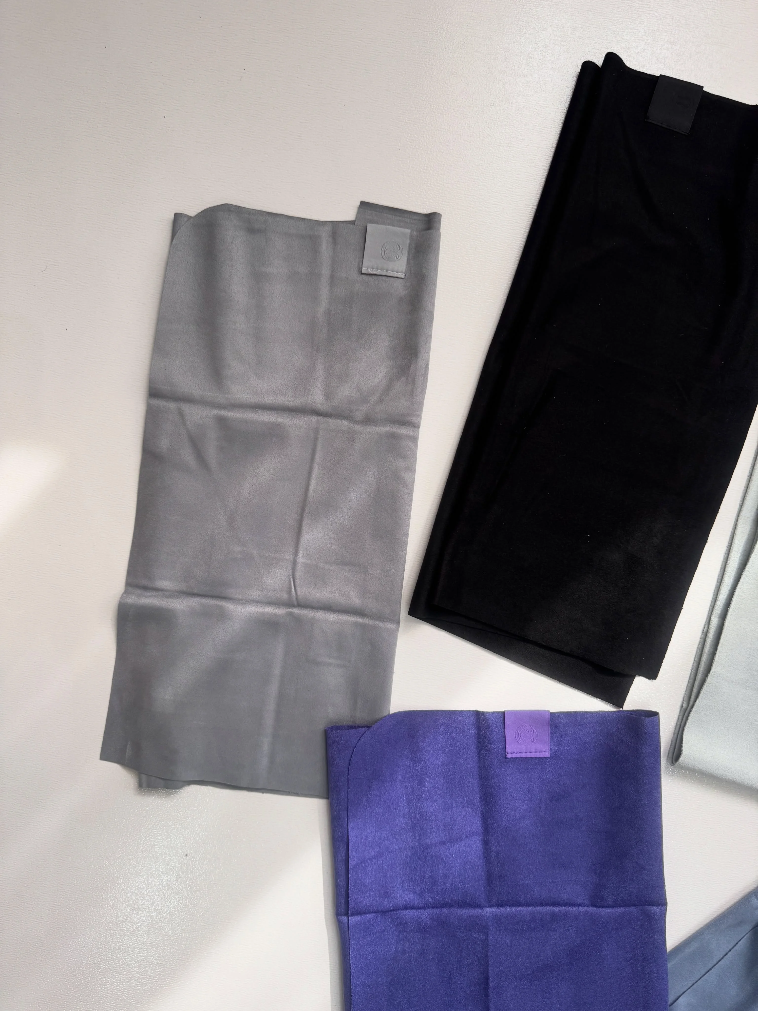 حوله کوچک Lululemon طوسی؛ نمای بافت و لوگوی گوشه در کنار مشکی و بنفش