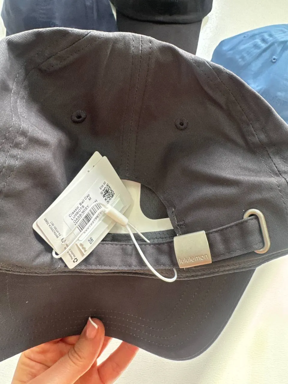 نمای پشت کلاه بال کپ کلاسیک Lululemon طوسی تیره با بند پارچه‌ای، سگک فلزی و تگ Classic Ball Cap
